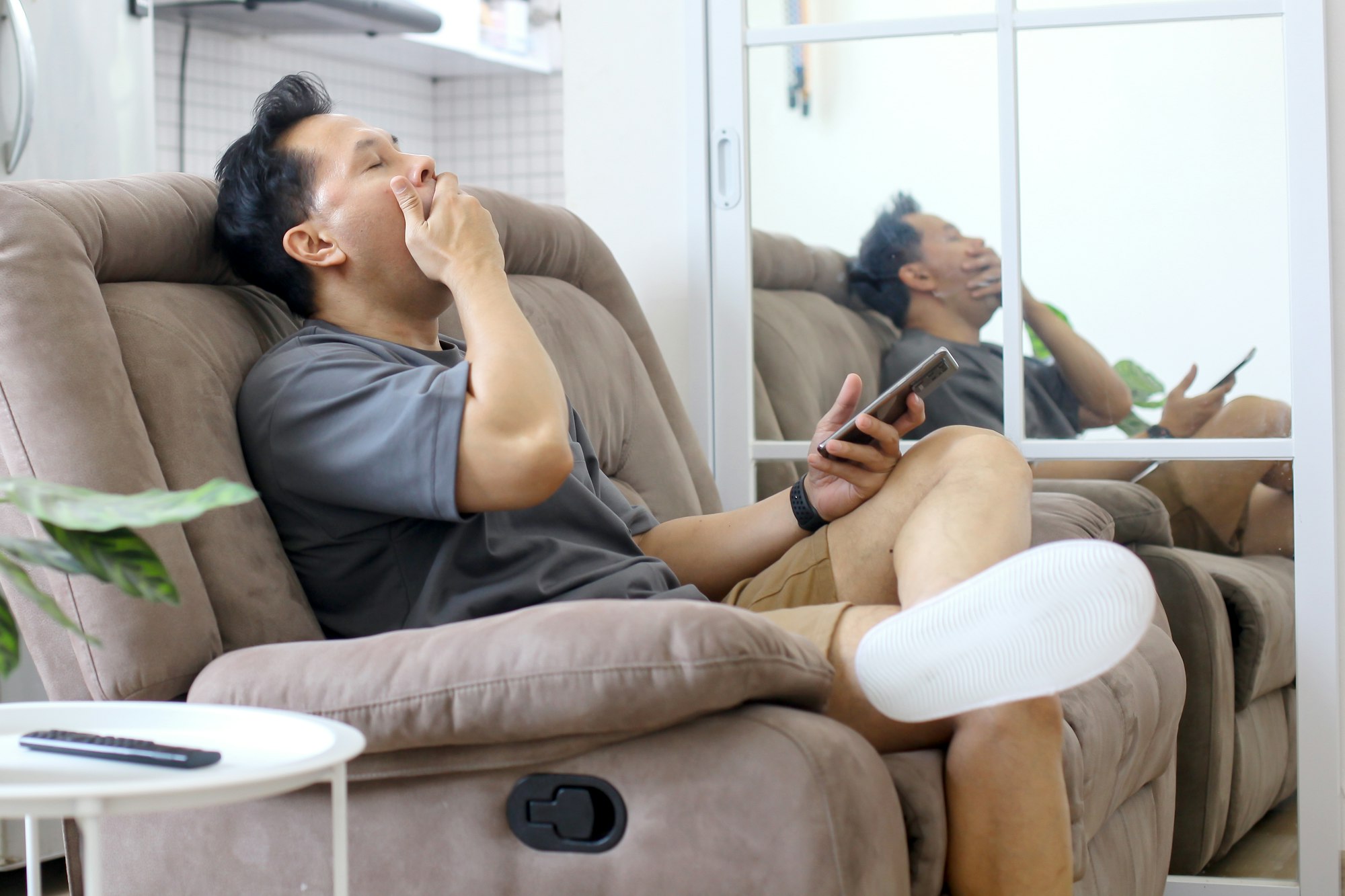 Man Yawning on Sofa